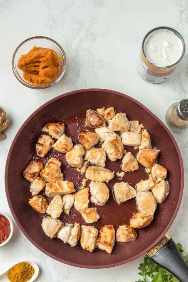 cooking chicken pieces in a skillet