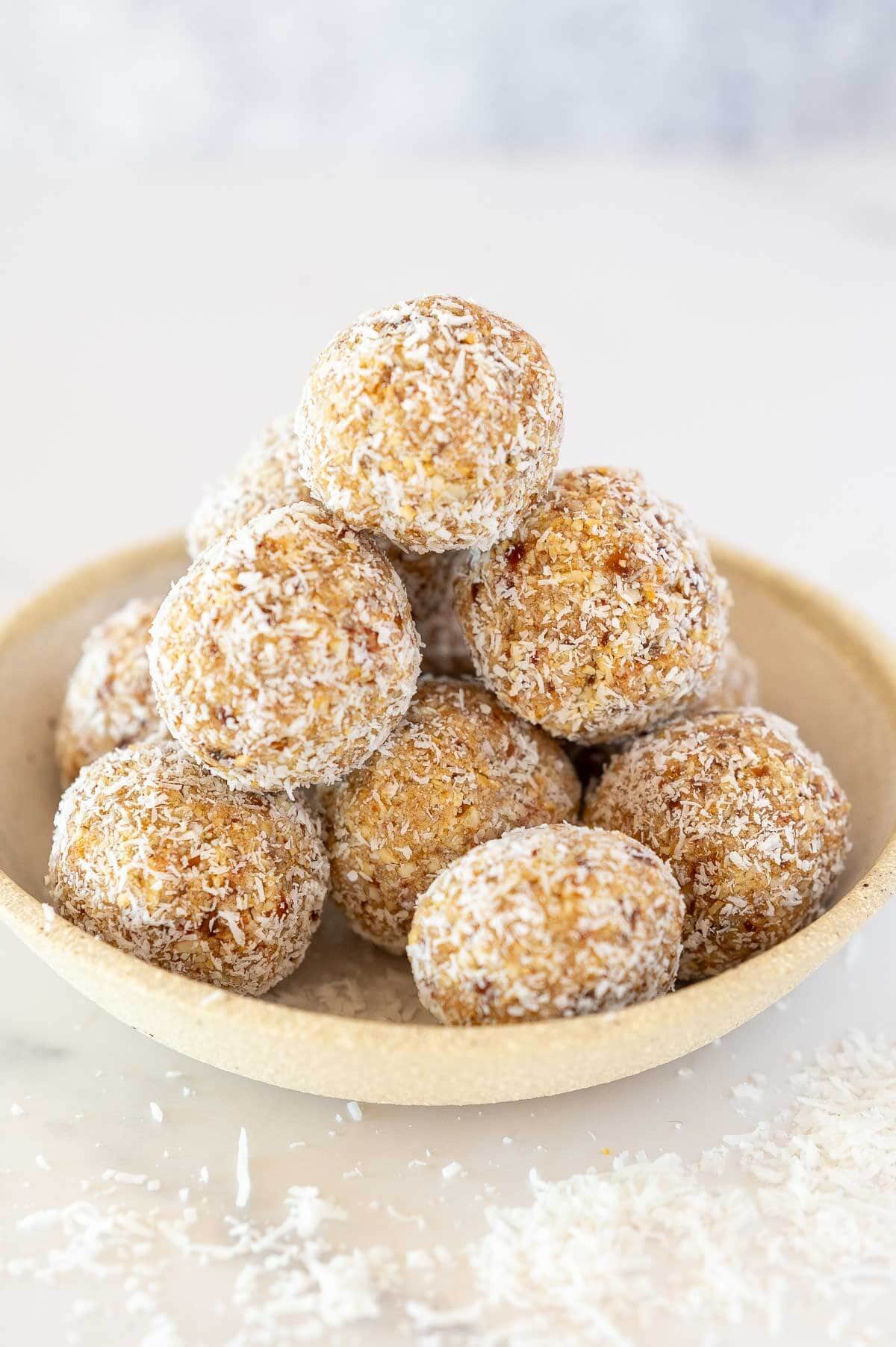 coconut protein balls stacked in a bowl