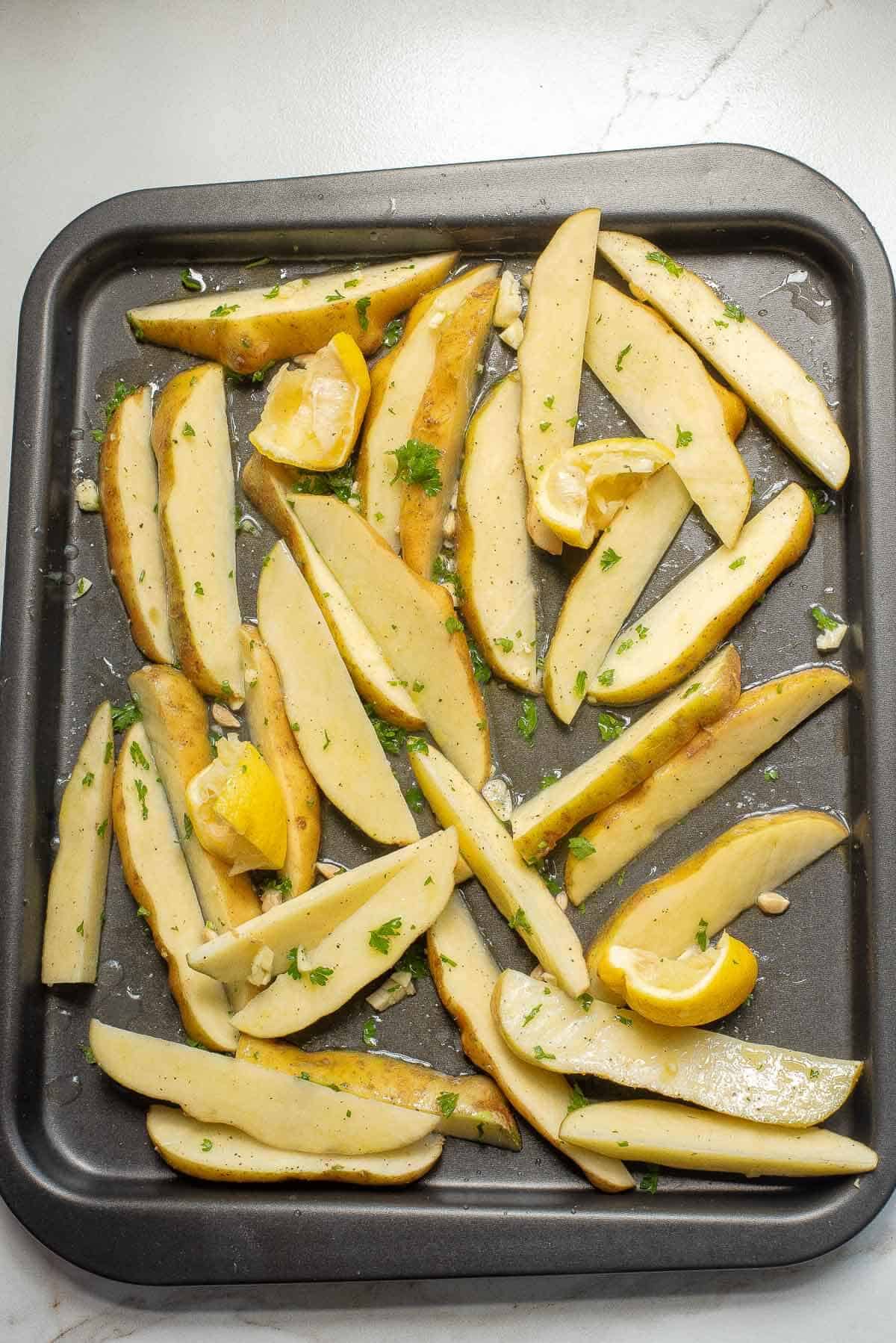 uncooked potato slices on a baking sheet