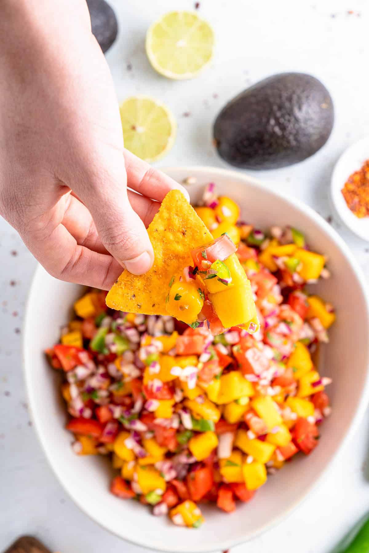 tortilla chip scooping up mango salsa