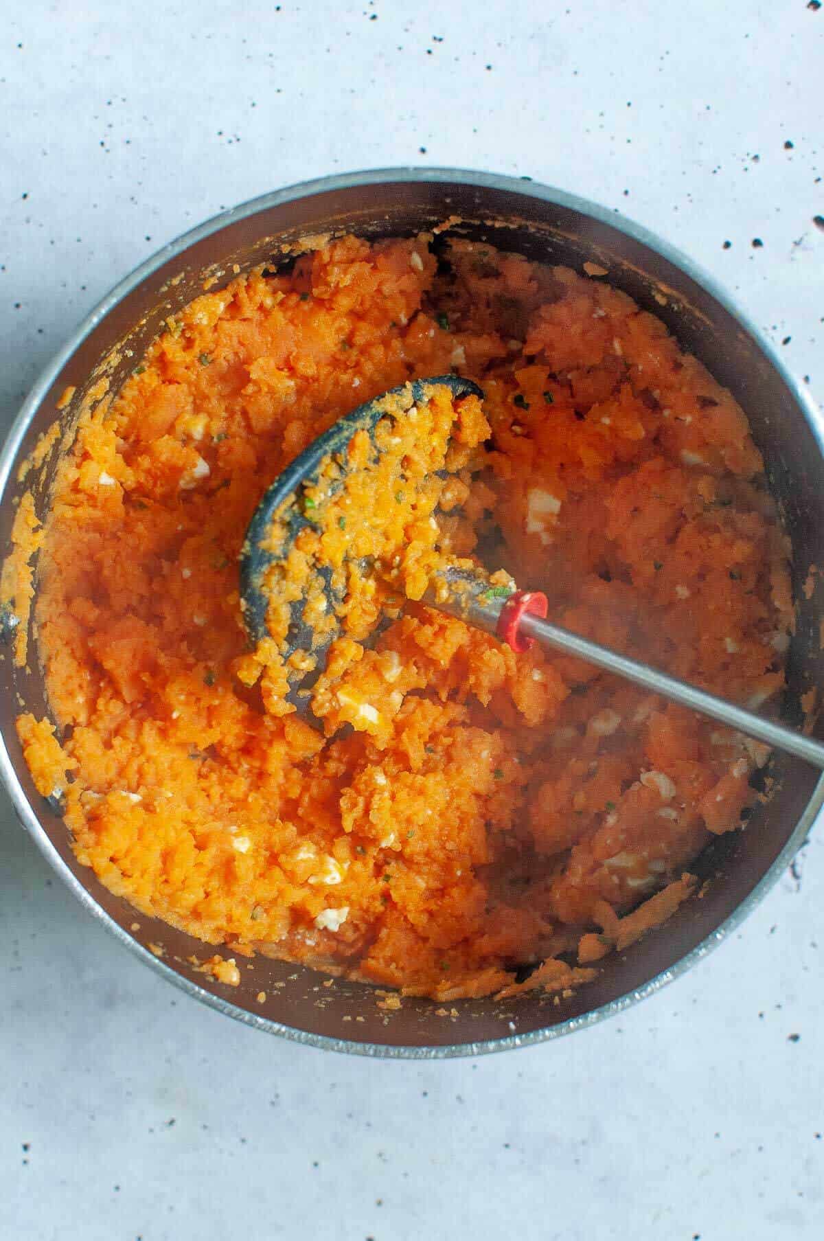 mashing shepherds pie in a pot