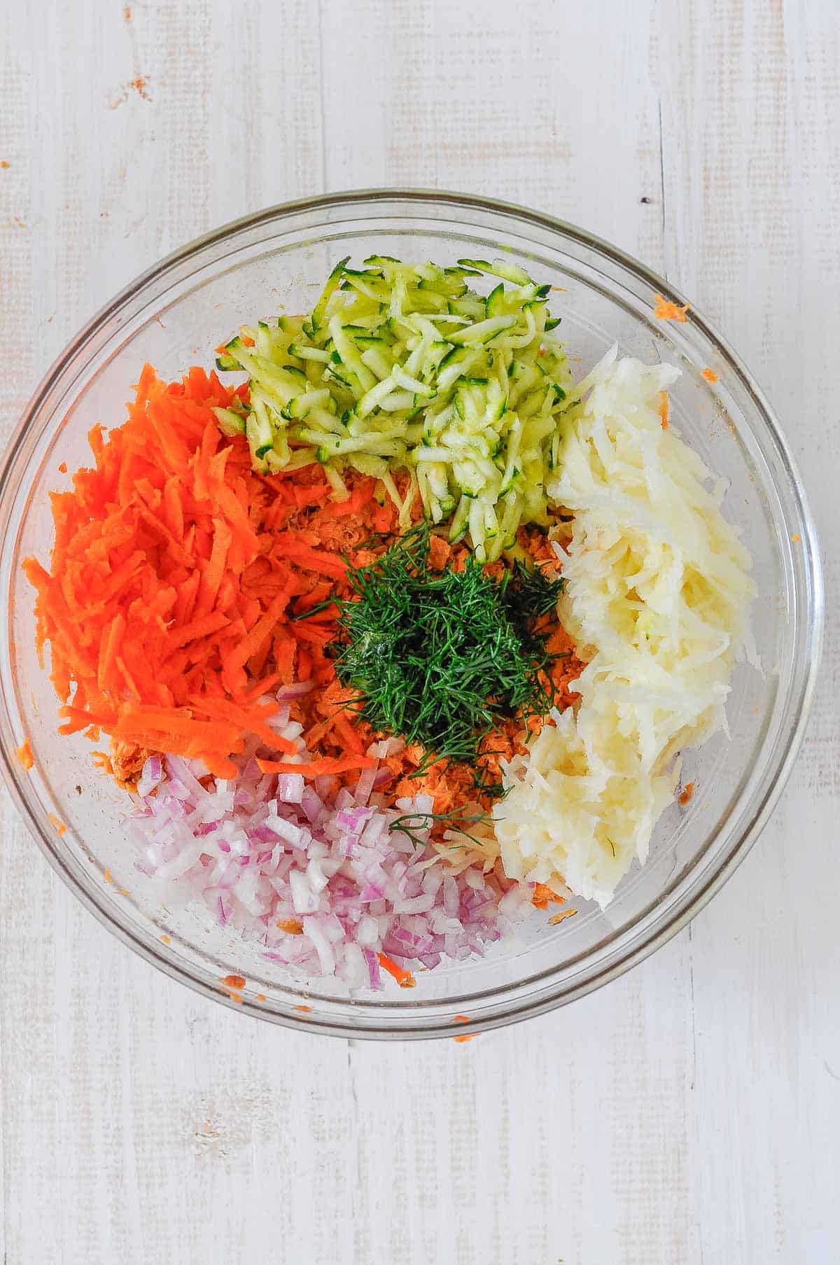 grated carrot, grated zucchini, red onion and grated potato and dill in a large bowl