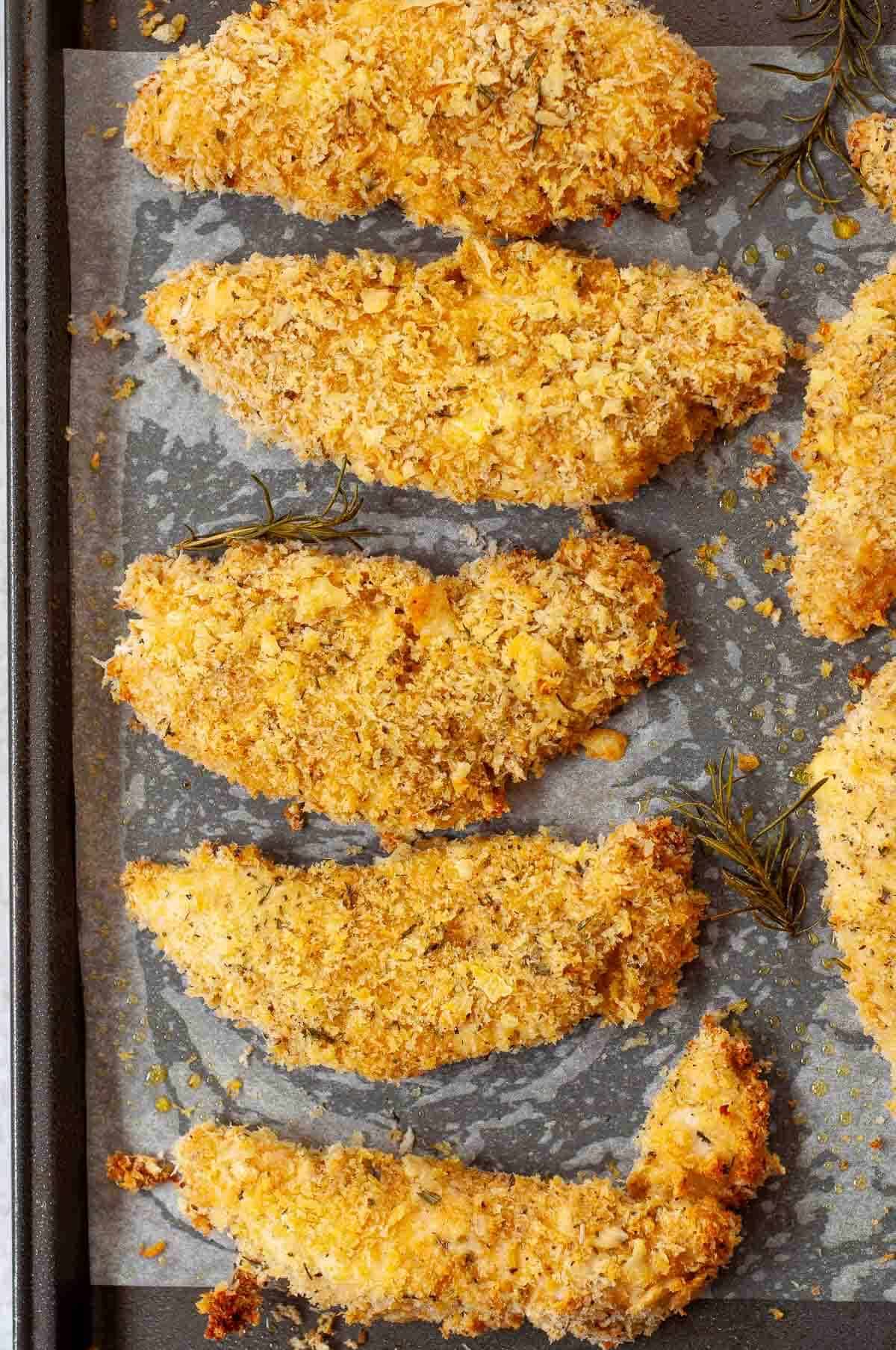 cooked chicken fingers with panko breadcrumbs on a tray