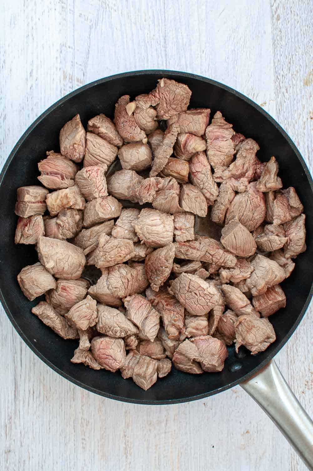 browning gravy beef chunks in a pan