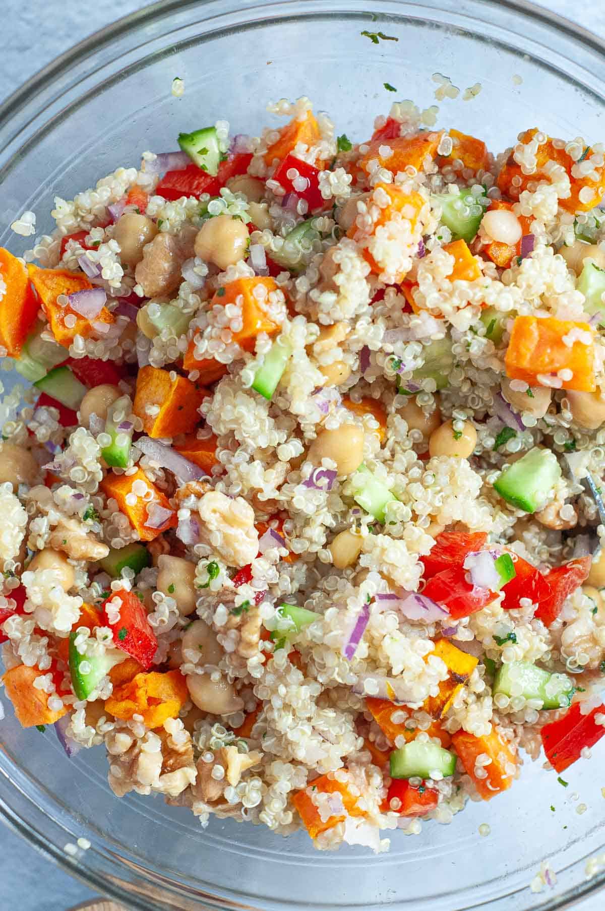 white quinoa salad with vegetables in a glass bowl