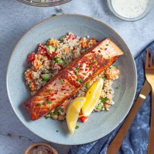 salmon fillet and quinoa bowl with lemon wedges