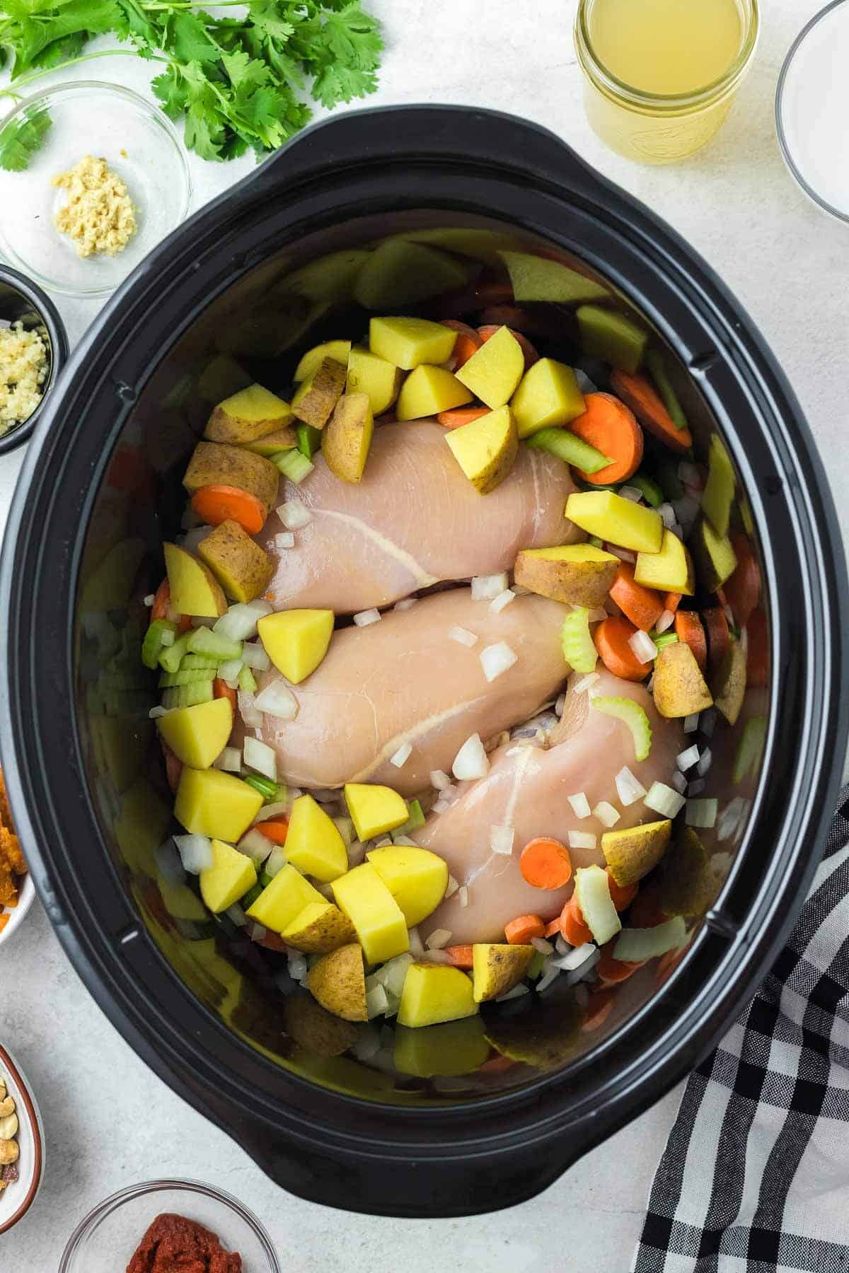 raw chicken and vegetables in crockpot