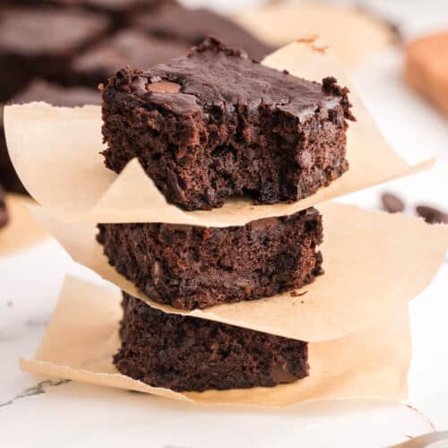 stack of 3 brownies with a bite taken out of the one on top