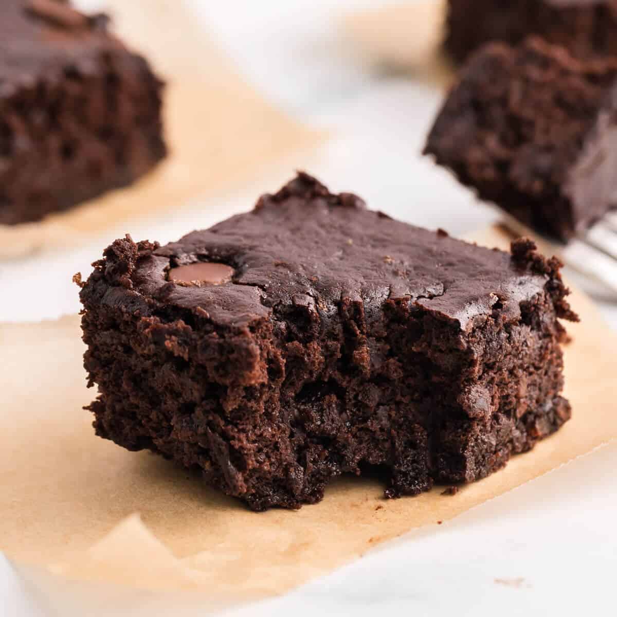 a single brownie on brown paper with a bite taken out