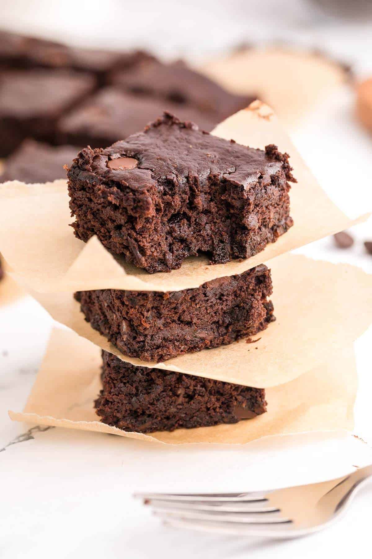 a stack of 3 brownies separated by brown paper