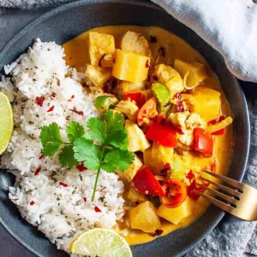 chicken pineapple curry with rice in a bowl with fork
