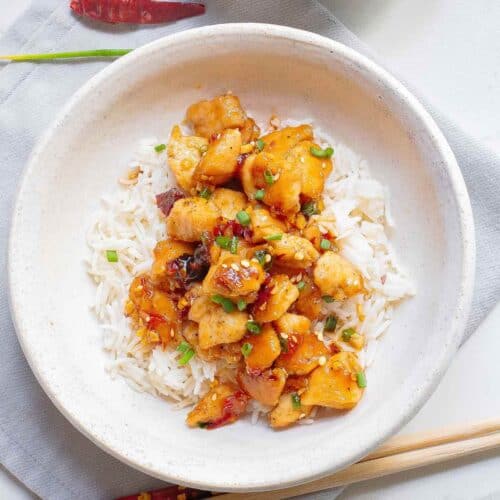 White bowl with rice and gochujang chili chicken breast pieces