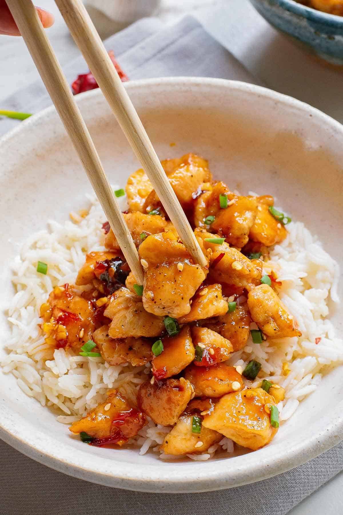 chopsticks picking up spicy chili chicken pieces