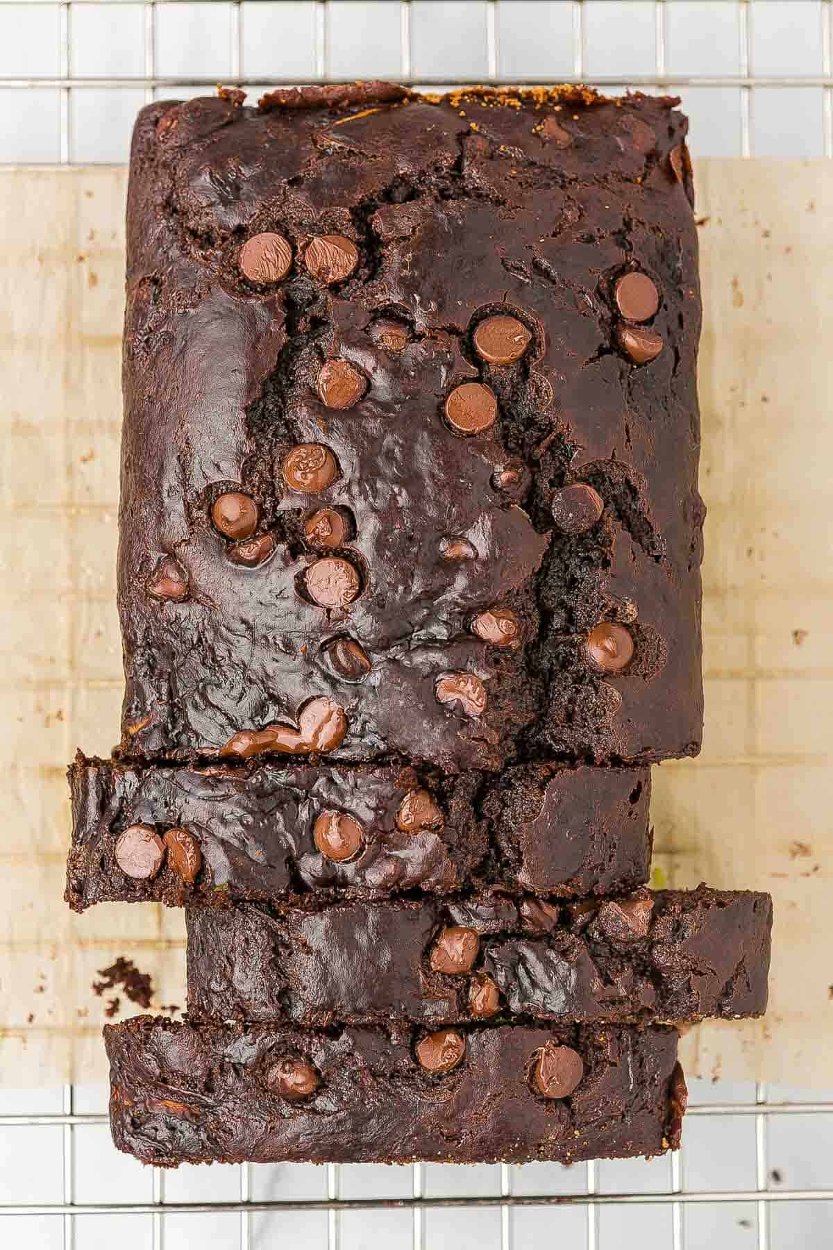 A loaf of chocolate zucchini bread with 3 slices