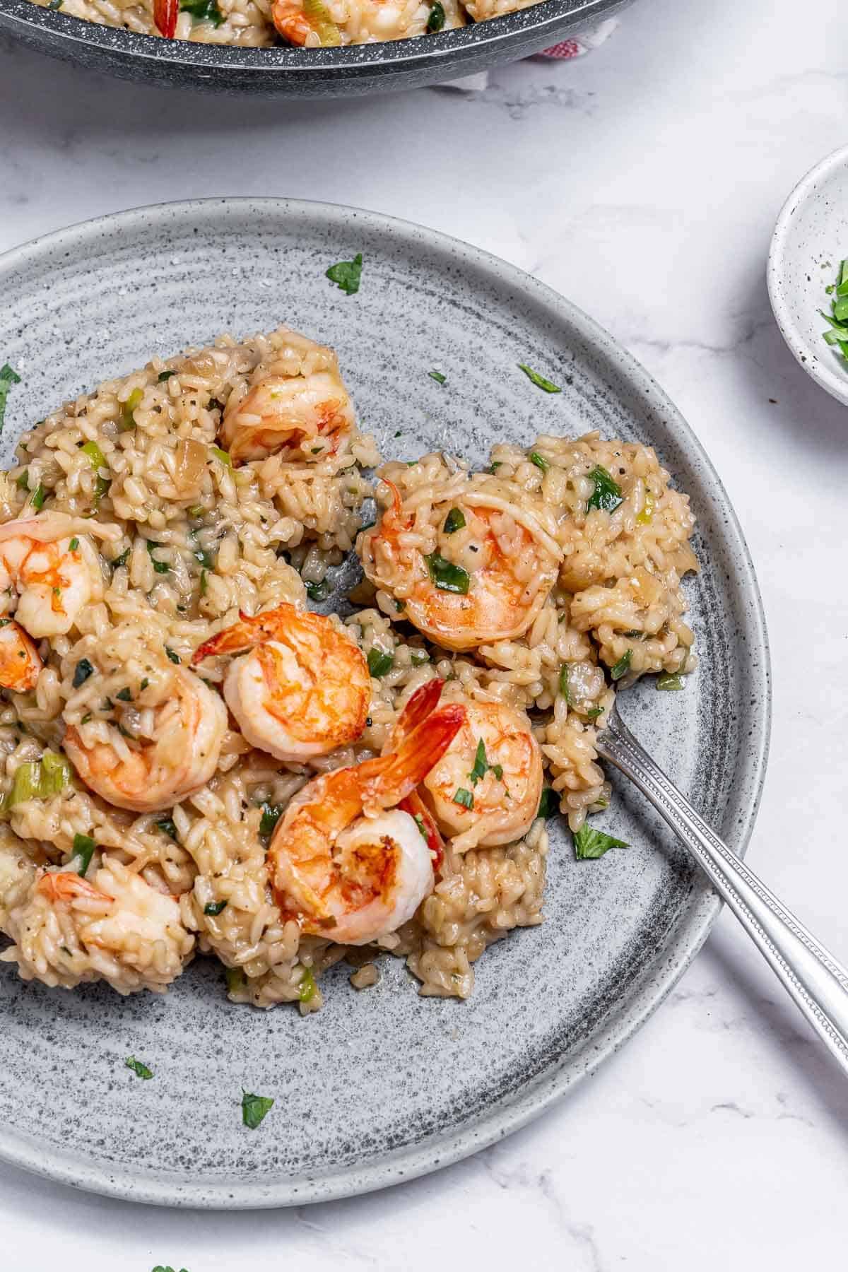 shrimp risotto on a plate with a fork