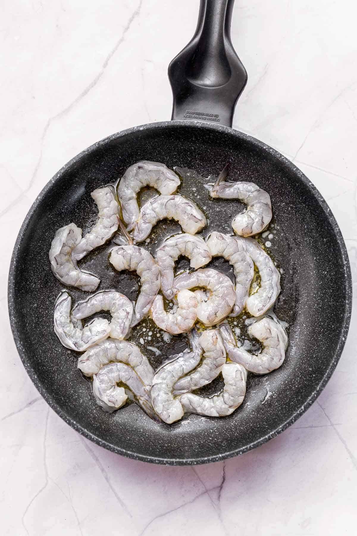raw shrimp in a skillet