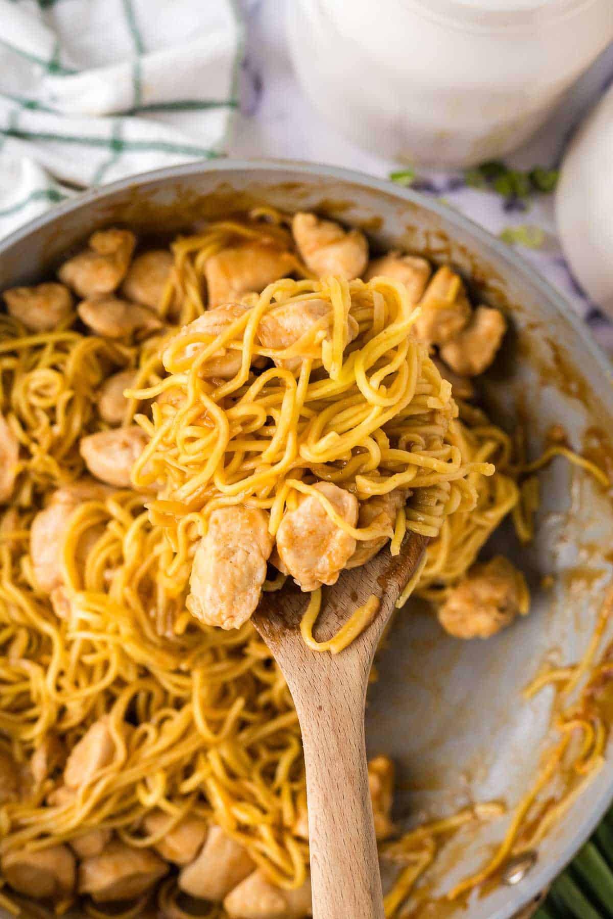 chicken and noodles on a wooden spoon
