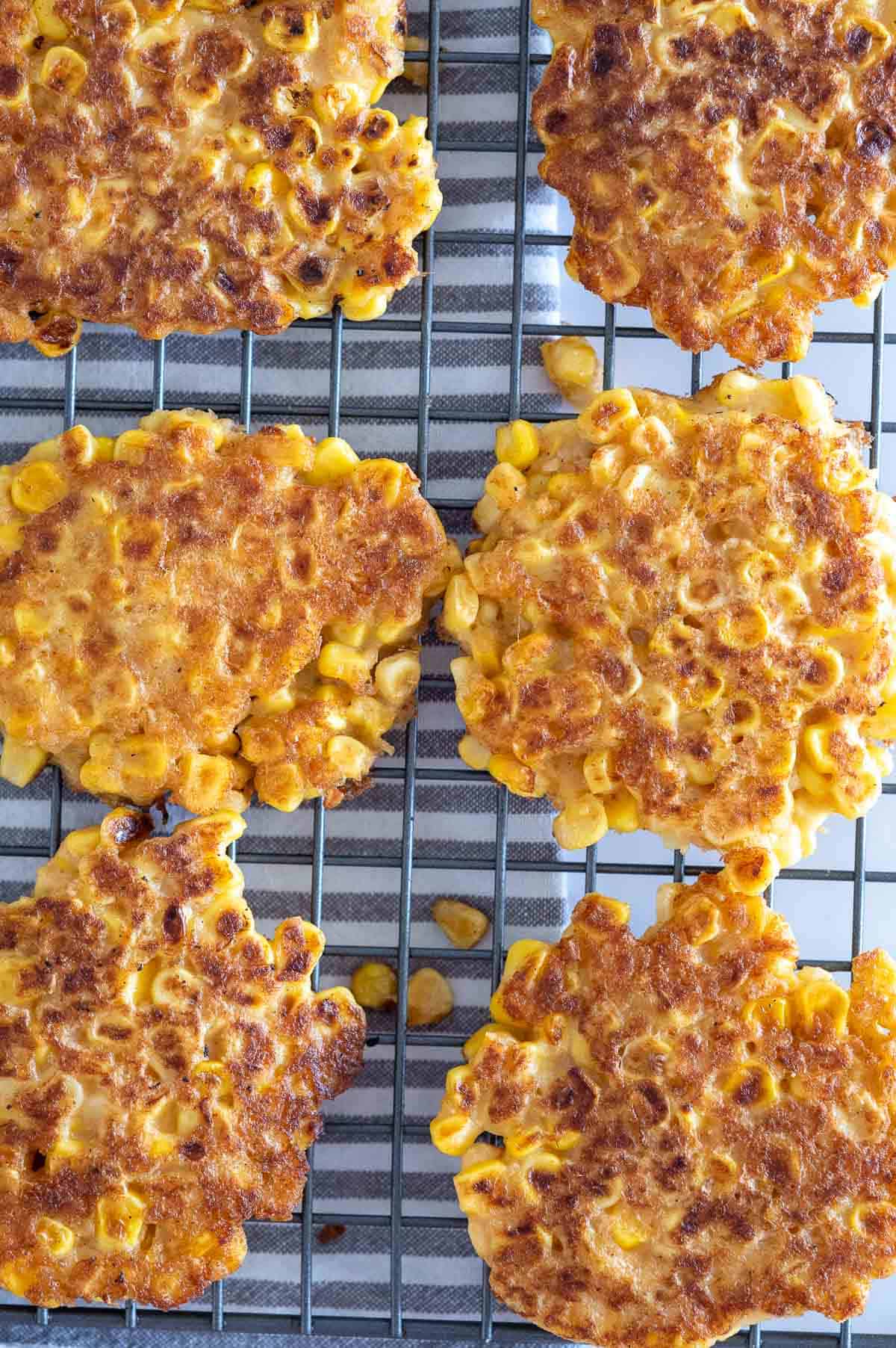 Six healthy corn fritters on a wire rack