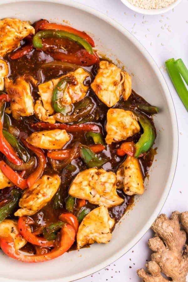 chicken and bell peppers in black pepper sauce in a skillet