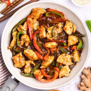a skillet of cooked chicken, black pepper sauce and bell peppers