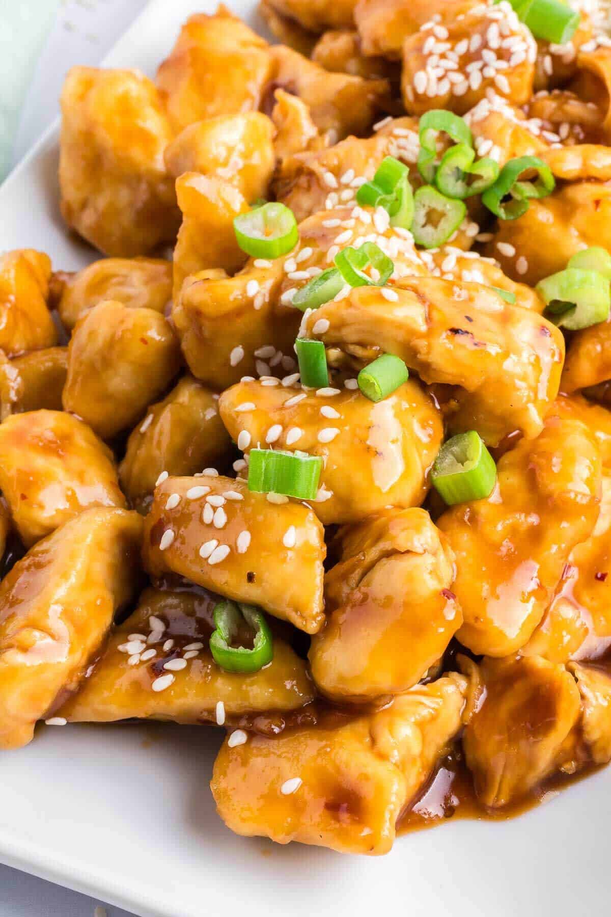 diced chicken pieces covered in healthy general tso sauce sprinkled with sesame seeds on top