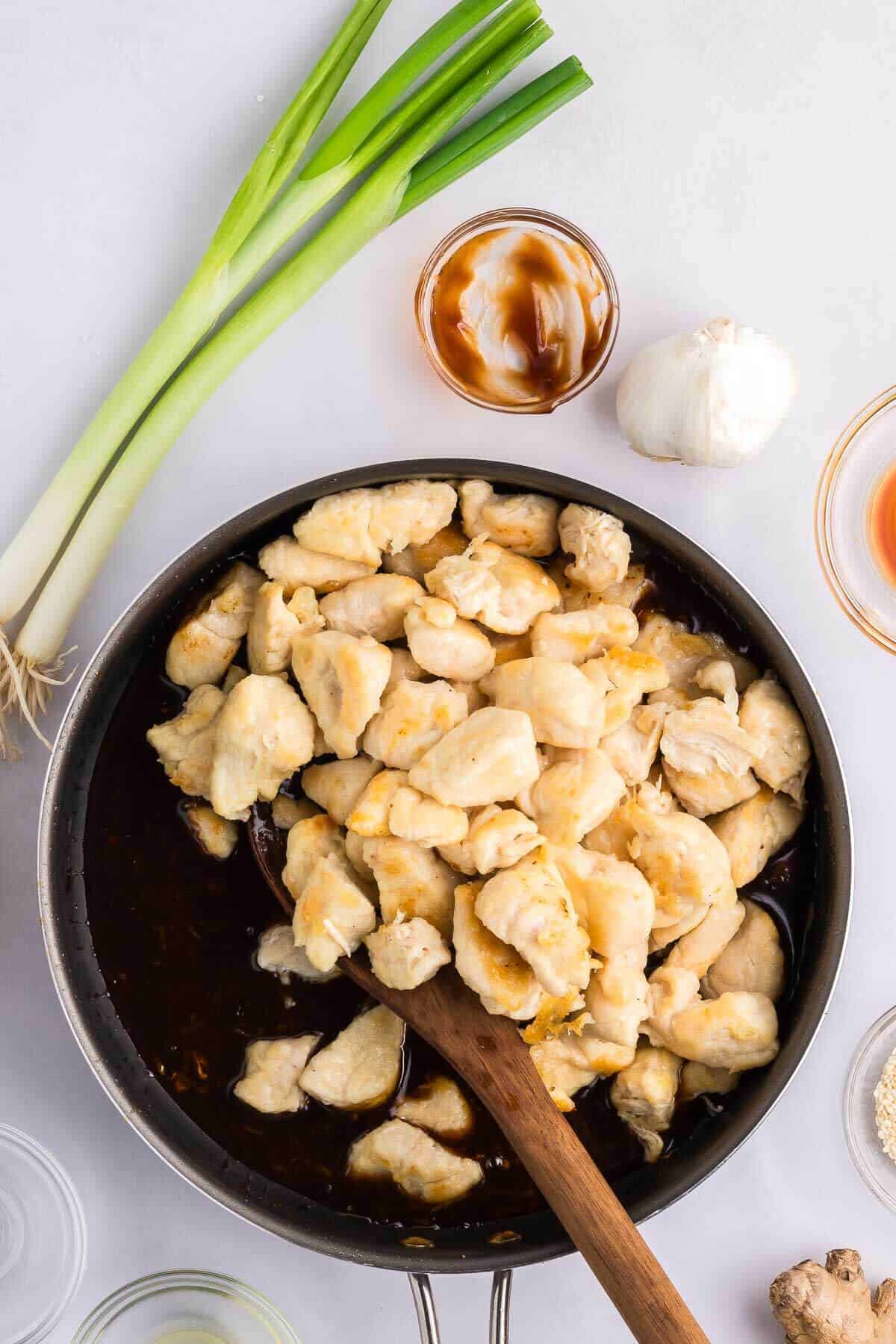 skillet of cooked chicken bites with healthy general chow sauce