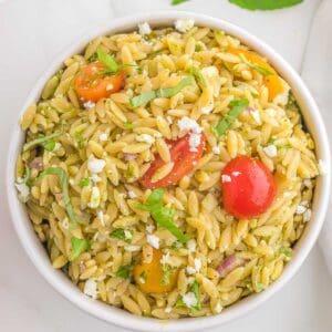 a bowl of feta tomato basil pest orzo salad