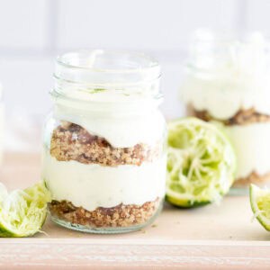 lime cheesecake in a cup with lime wedges