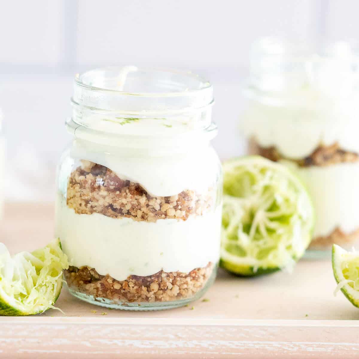 lime cheesecake in a cup with lime wedges